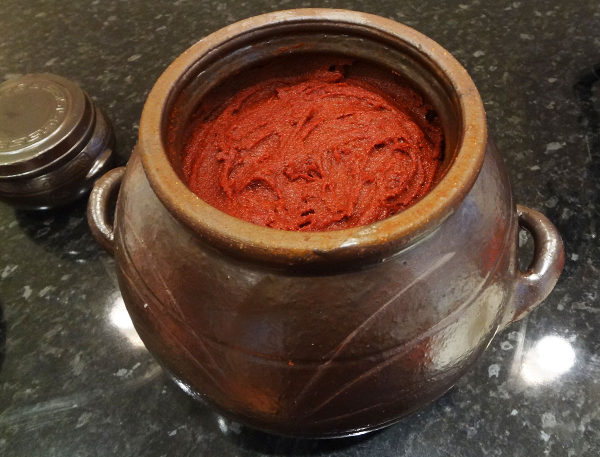 a ceramic vessel filled with red chili paste