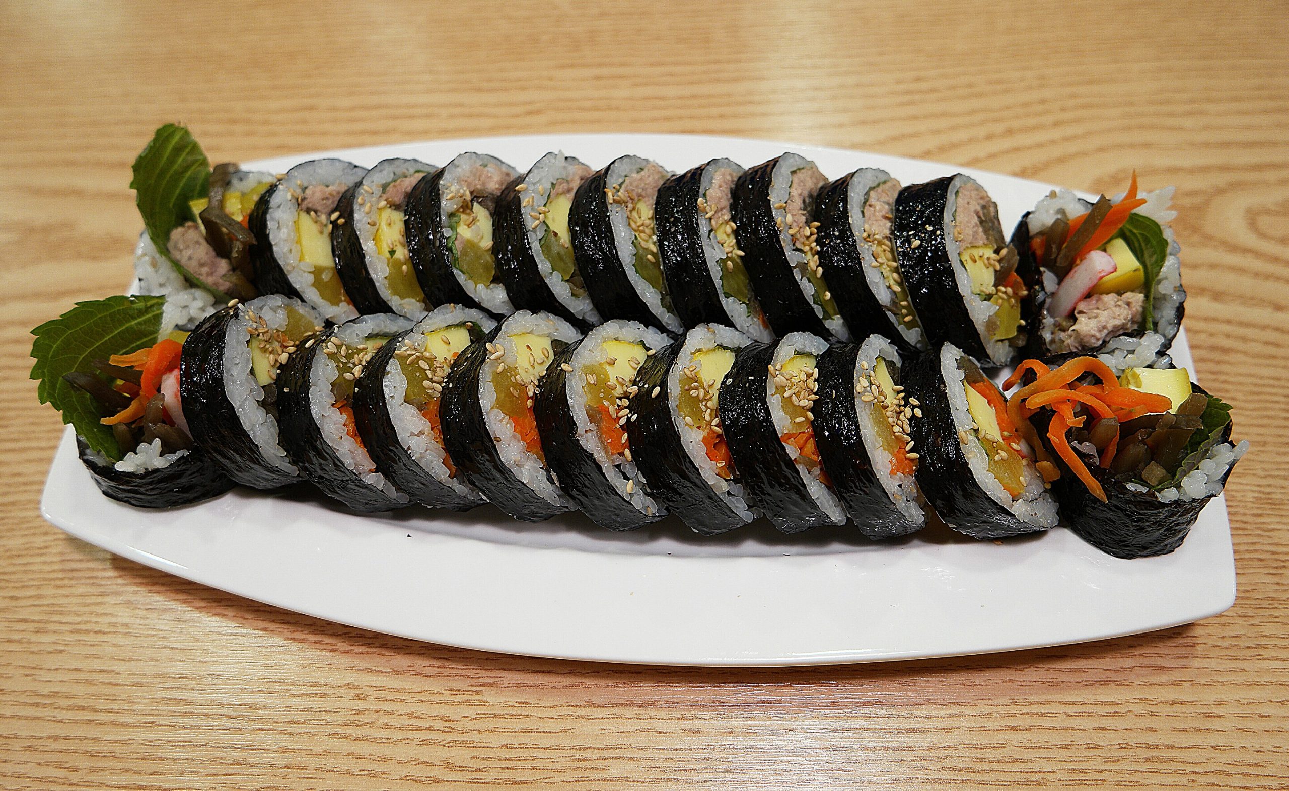 Slice Gimbap, rolls wrapped in seaweed, filled with rice, vegetables,and egg, topped with sesame seeds